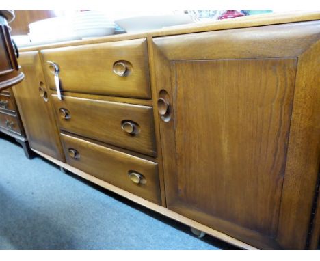 A vintage dark elm Ercol "Windsor" pattern sideboard. H156cm x D46cm x H69cm.