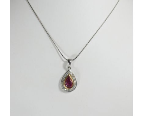 An 18ct white gold ruby and diamond tear drop shape pendant, set with tear drop shape ruby in yellow gold setting surrounded 