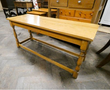 A long light oak coffee table on turned legs 
