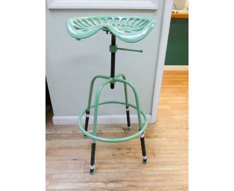 A green adjustable tractor stool 