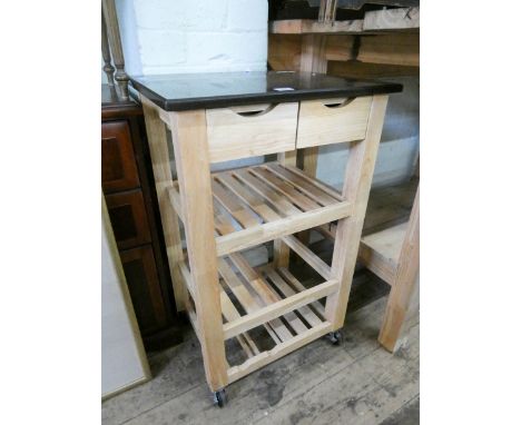 A light beech finished kitchen workstation with black marble effect top, shelves and drawers under 
