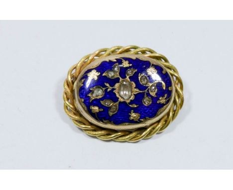 Blue enamel and five cut diamond oval brooch with rope twist border, gross weight 24.5gms 