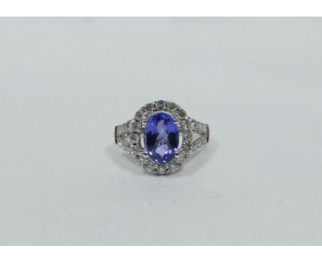 Large modern Tanzanite and diamond cluster ring, set with a large mixed cut oval tanzanite of good colour to the centre, surr