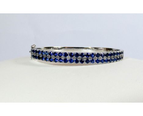 Modern 18ct white gold ladies hinged bangle set with a double row of sapphires, gross weight 26gms 