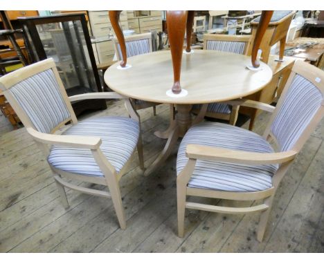 A circular light beech effect single pillar dining table together with four elbow chairs with striped upholstered seats and b