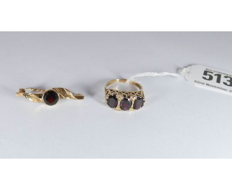 A three stone garnet 9ct gold ring and a bar brooch set with circular garnet in a rub over setting, ring size Q 