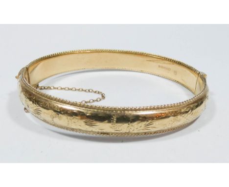 A ladies 9ct yellow gold hinge bangle with safety chain fitting 14.2gms 