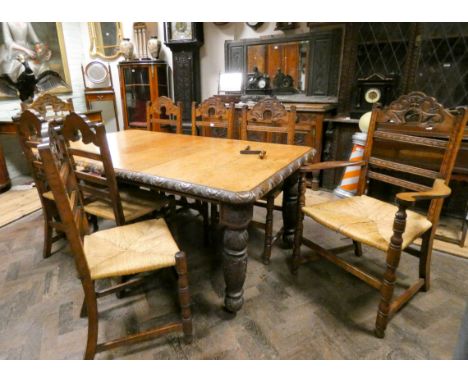 A late Victorian carved oak dining room suite, the large medium oak table with carved frieze standing on carved legs, with tw