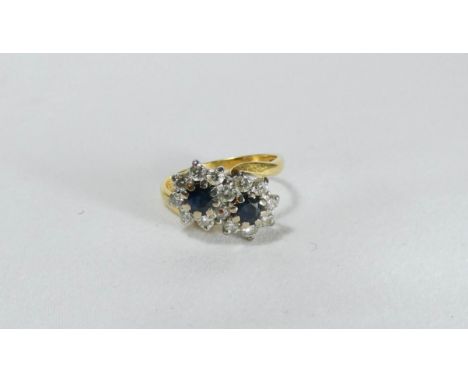 A sapphire and diamond ring, cross over design of circular clusters, hallmarked 18ct yellow gold shank, ring size K/L