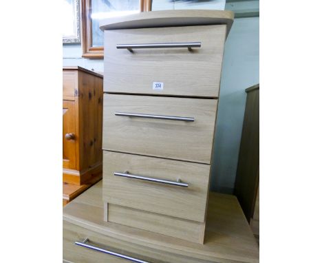 A modern light oak finished bedside chest of three drawers matching the previous lots 