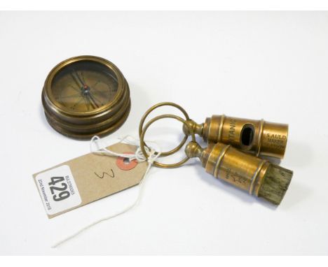 Two Titanic brass whistles and a Titanic compass 