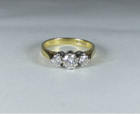 An 18ct gold three stone diamond ring, ring size K   The weight and dimensions are approximately as follows:Weight -2.9gMiddl