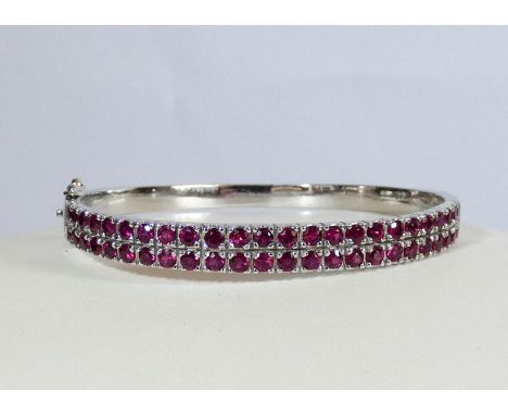 Modern 18ct white gold ladies hinged bangle set with a double row of rubies of good colour, gross weight 28gms 