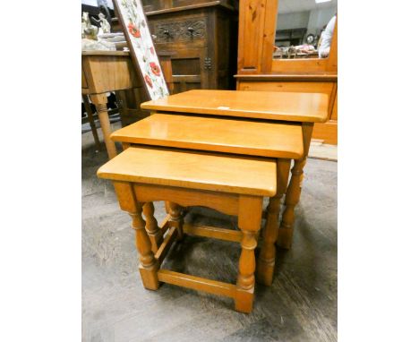 A nest of three reproduction light oak coffee tables 
