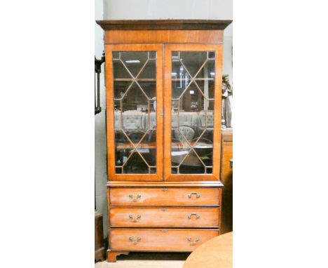 A Georgian style mahogany lattice glazed two door bookcase standing on base fitted three long drawers with bracket feet 3'6 w