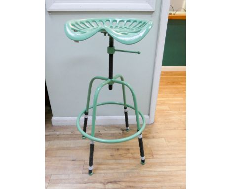 A green adjustable tractor stool