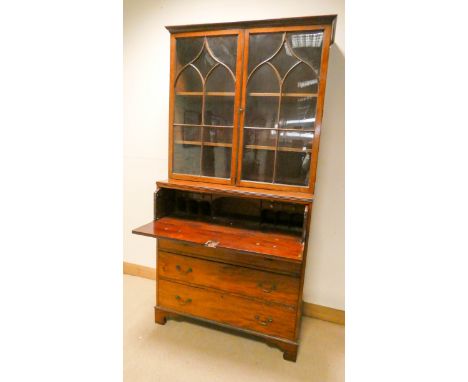 A Georgian mahogany secretaire bookcase with glazed lattice doors fitted interior and three long drawers under standing on br
