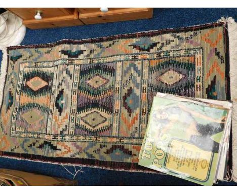 A vintage Aztec style rug twinned with 14 compilation type albums from the 1970's