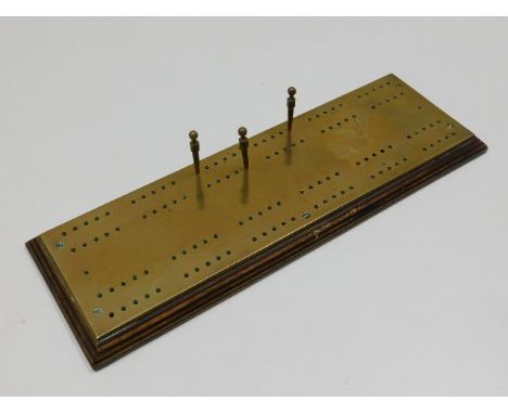 A brass cribbage board 12.75in long x 4.25in wide 
