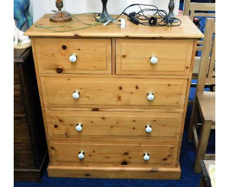A pine chest of five drawers with ceramic fittings