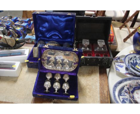 A boxed decanter set and four glasses; and two boxed silver plated items