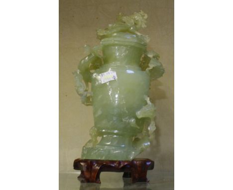 A 20th Century jade vase with cover on wooden stand, 28cm high (af)