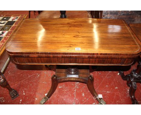 A Regency mahogany and brass inlaid card cable, circa 1815, the lift top opening to baise playing surface and swiveling to co
