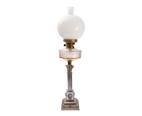 An Edwardian metal and moulded glass columnar table oil lamp, early 20th century; with flue and spherical milk glass shade to