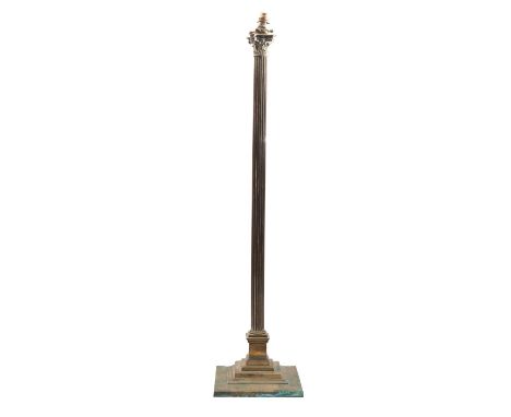 A brass columnar standard lamp, late 19th century and later converted from oil; the electrical fitment above a Composite capi