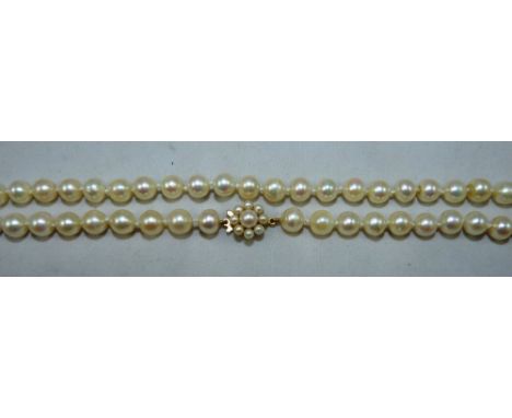 A single row cultured pearl necklace of uniform form, comprising seventy five 7mm beads, to a 9ct gold and pearl cluster clas
