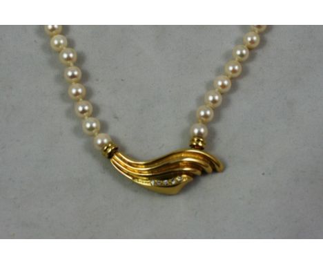A uniform cultured pearl necklace with an 18ct gold and diamond panel front, composed of 58 beads of 6.5 mm diameter, weight 