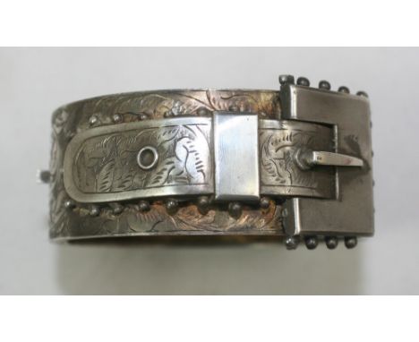 A Victorian silver hinged bangle, Birmingham 1884, the front with an applied buckle.