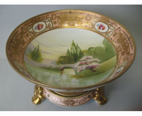 A Japanese Noritake bowl, of circular pedestal form, the centre painted with a river landscape scene with swans beneath a bri