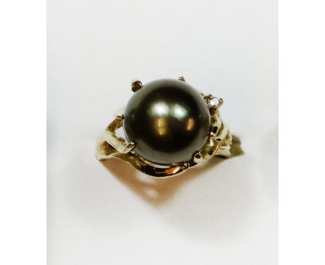 A 14k gold, black pearl and diamond dress ring, abstract set with a 12 mm pearl and a brilliant cut diamond, size O 1/2.