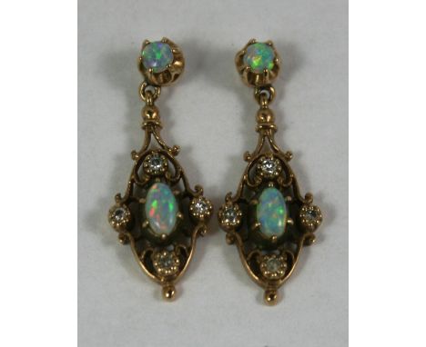 A 9ct gold pair of opal and diamond drop ear rings, the central cabochon cut stone bordered by four single cut diamonds, opal