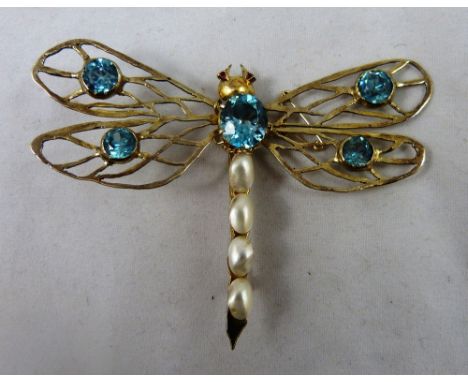 A silver gilt gem set butterfly brooch, claw set with blue zircons and baroque pearls, ruby set eyes, wing span 82 mm.