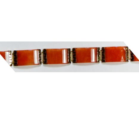 A 14 k gold and brown jade panel link bracelet, the arched rectangular panels with geometric pierced links between, (jade unt