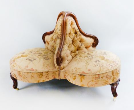 A Victorian walnut framed three-seater conversation settee, of trefoil shaped form, the carved dividers with re-upholstered d