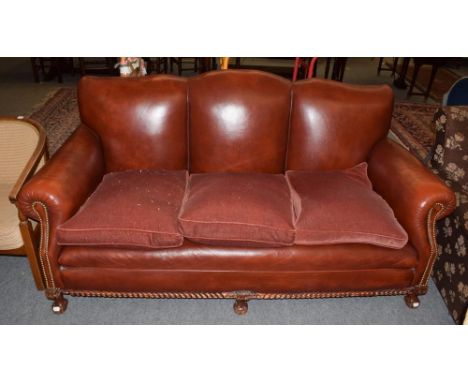 ^ A modern red leather three-seater sofa with studded decoration 