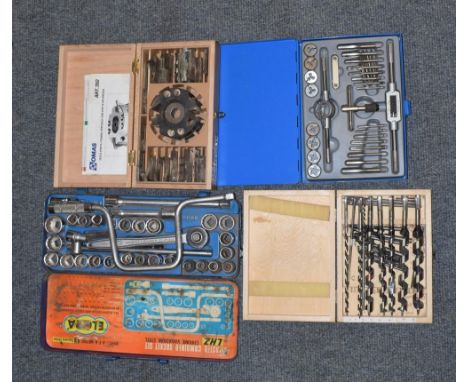 Four sets of modern tools: drills, tap and dye set, profile cutter and socket set 