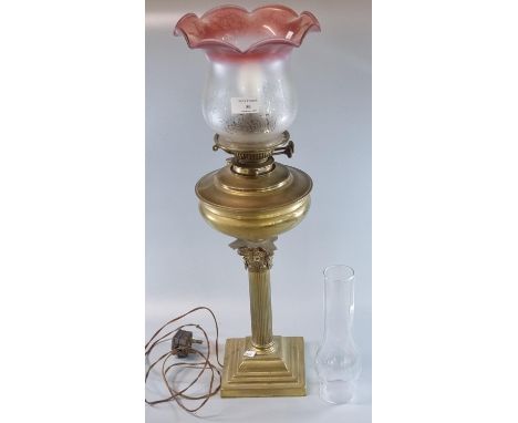 Early 20th century double oil burner lamp now converted to electricity, having clear and frosted cranberry glass shade above 