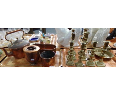 Two trays if metalware: four pairs of cast brass candlesticks with candle pushers and a brass night light with candle pusher,