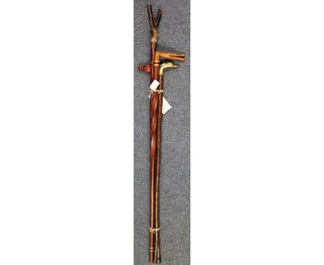 Four walking sticks to include: thumb stick, horse's head stick, crocodile shaped hardwood stick and a brass duck's head walk