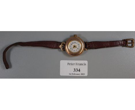 Early 20th Century lady's gold wristwatch, converted from a pocket watch, with enamel Arabic face, now on leather strap. Unma