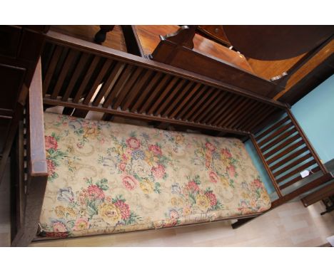 An Arts and Crafts oak bench, slatted back, floral patterned seat