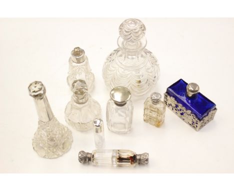 A collection of silver topped glass scent bottles; together with a moulded glass decanter and another 