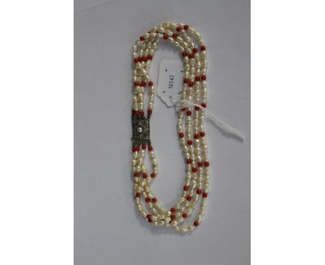 A freshwater pearl and red coral bead four strand choker necklace with sterling silver and marcasite clasp 