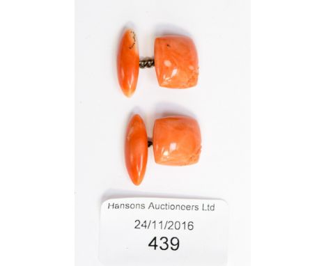 A pair of circa 1920s coral cufflinks, each having floral carving to one corner 