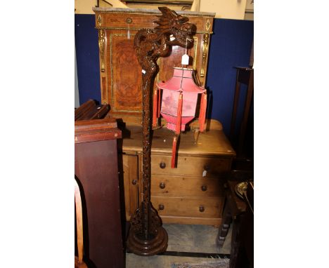 A 20th Century oak carved standard lamp, in the Chinese style, the upper section in the form of a Chinese dragon with a pagod