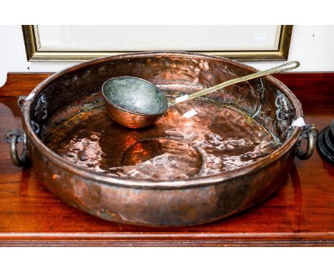 A twin handled shallow copper bowl, measuring approx 46 cms diameter, with a similar ladle, having brass handle and copper bo